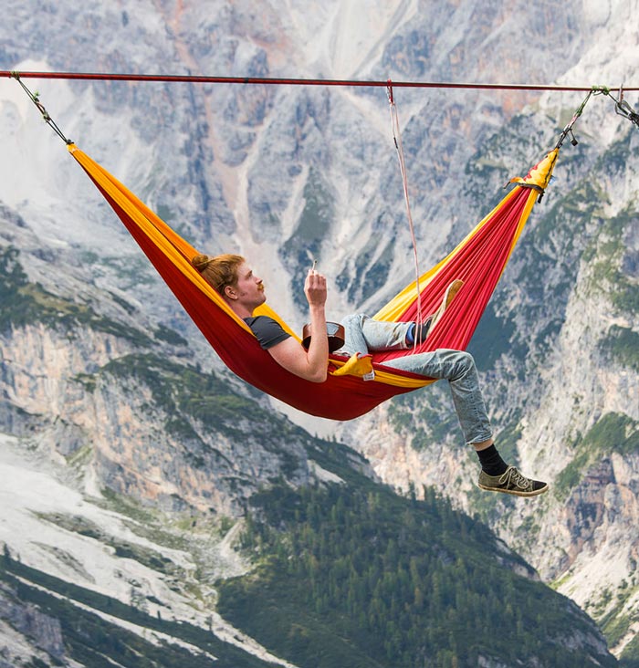 Man in a hammock on a slack line tight rope