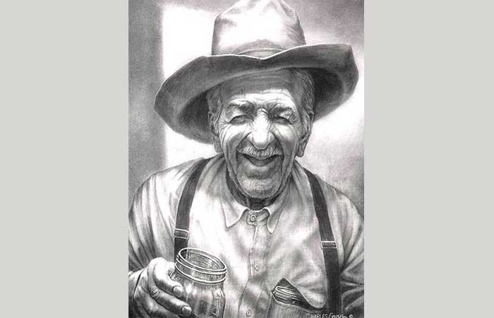 Old cowboy smiling with a glass of whiskey