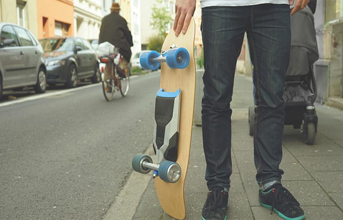 A guy holding Mellow Drive Electric Skateboard On The Street
