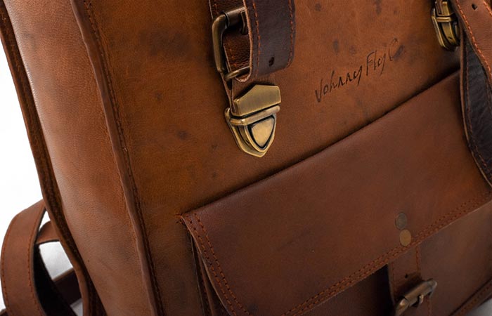 Leather Rolltop Backpack by Johnny Fly Co. zoomed in on the solid brass fittings and the front pocket.