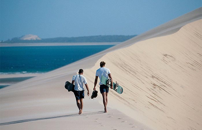 Two Guys Walking On A Sand Beach In Mozambique