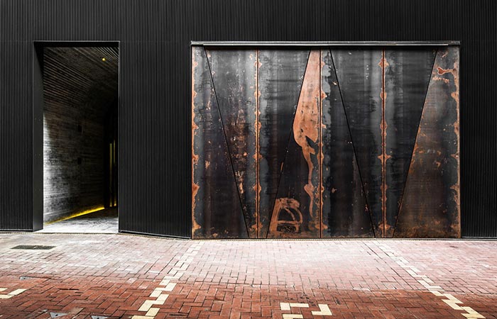 TUVE Boutique Hotel street view entrance with a warehouse-like look and rusty doors.