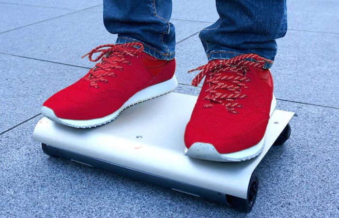 A person in red shoes riding a WalkCar. 