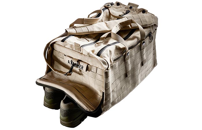 Able Archer Duffel, sand, side tilted view with a pair of shoes sticking out from one side.
