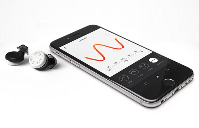 Doppler Labs Here Active Listening Earbuds and a black smartphone with a red curve on the screen, tilted, on a white background.