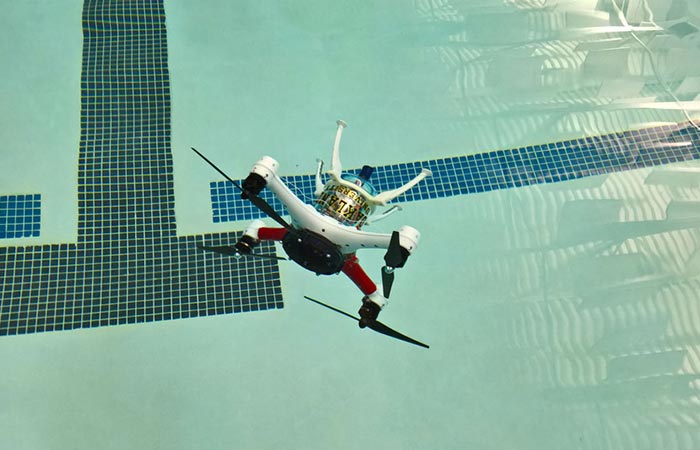 Loon Copter, tilted, flying just above the pool full of water.