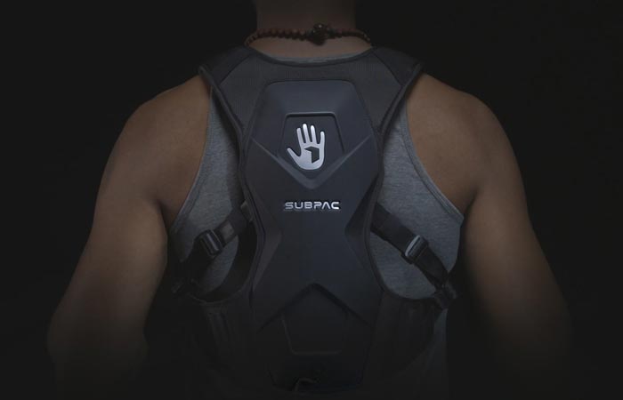 SubPac M2on the back of a man in a grey sleeveless shirt, with a black background.