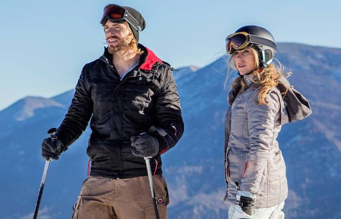 A man and a woman in the mountain wearing ThermalTech - The First Solar Powered Smart Jackets.