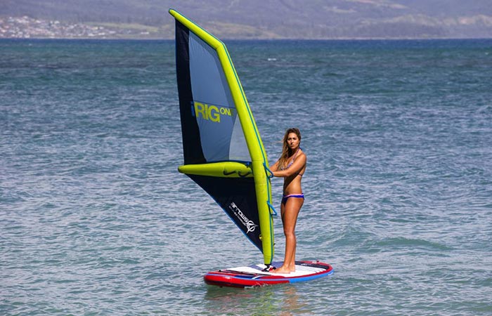 A woman windsurfing on water using the iRig One, tilted view.