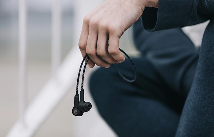 A Hand Holding Bang & Olufsen Beoplay H5 Wireless In-Ear Headphones