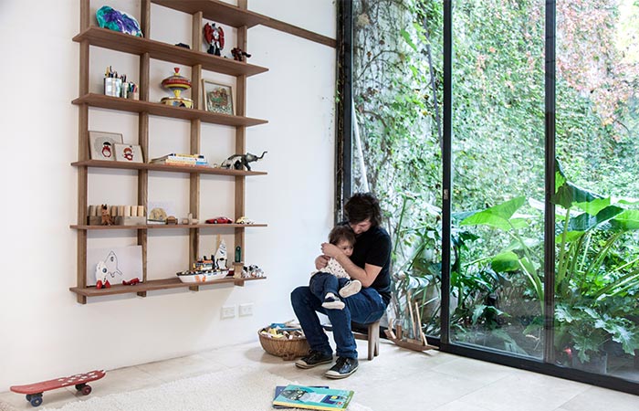 Man sitting with a child in front of Sticotti Bookshelf