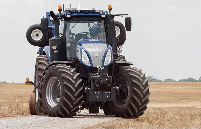 The New Holland T8 NH standing on a gravel path
