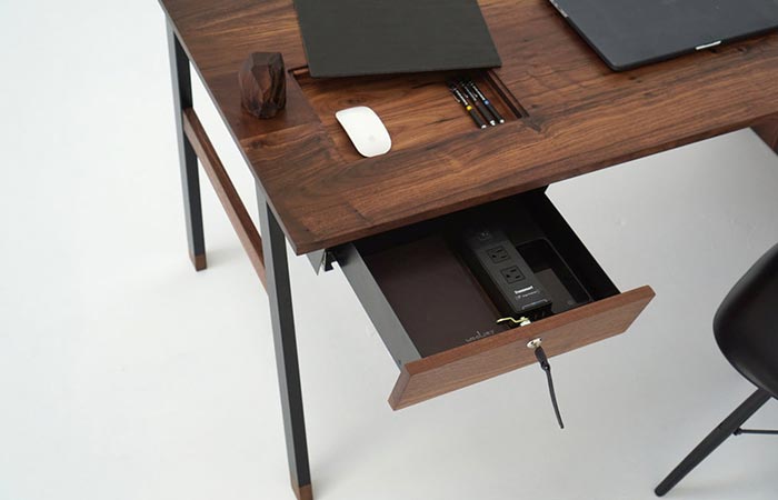 an opened drawer on a wooden desk