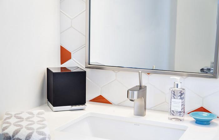 a black cube speaker in the bathroom