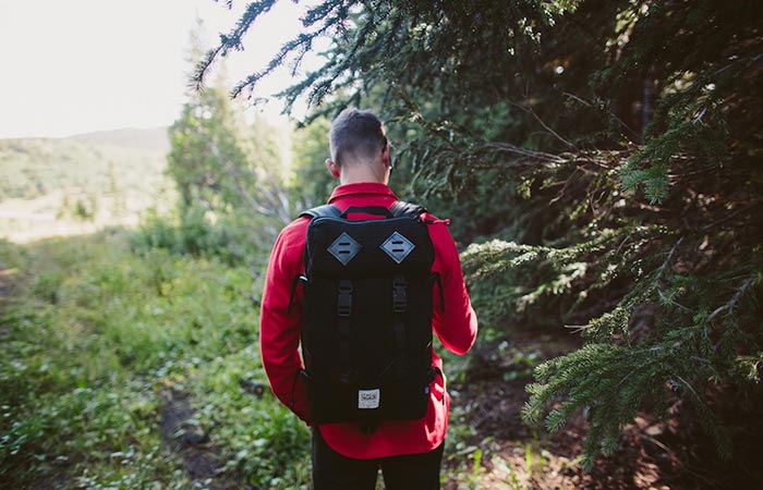 Man wearing the Topo Designs X Woolrich Klettersack Olive Waffle in the forest