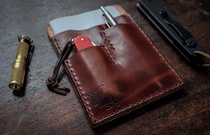 noteboook pen and pocket knife in a leather holder