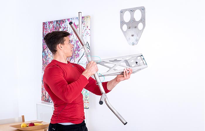 Man placing the Pullup & Dip on its indoor bracket