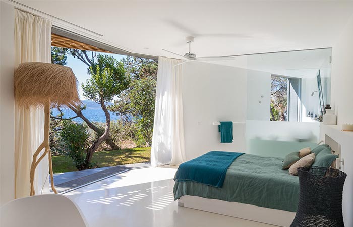 a bedroom with an open view of the sea