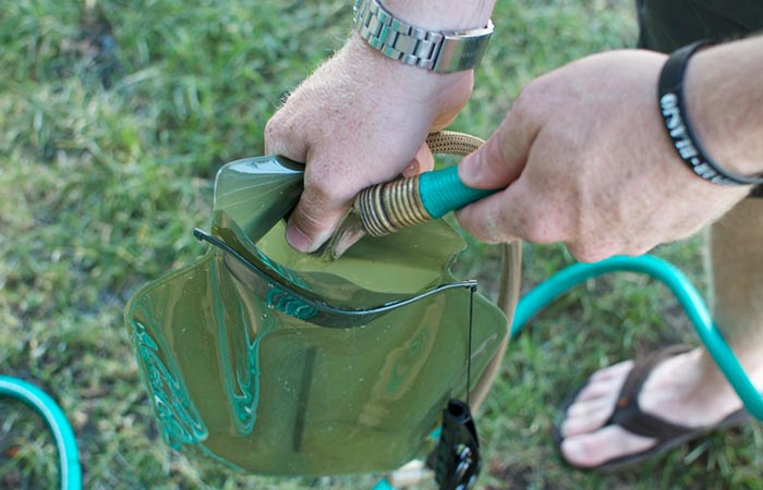 Somebody filling the GoRuck 3L Low Profile Hydration Bladder with water