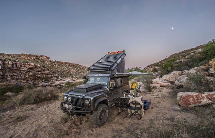 a land rover with a rooftop sleeping addition